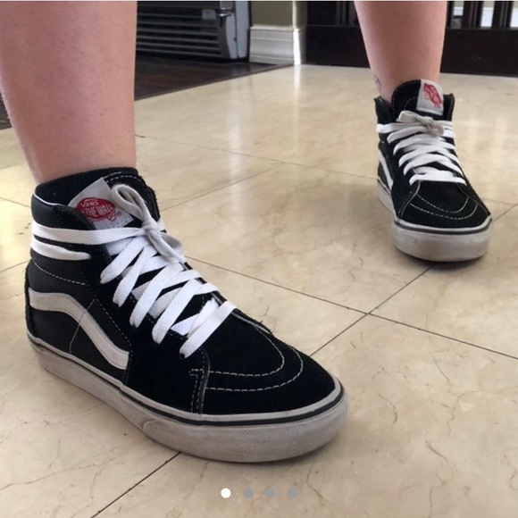 black low top vans on feet